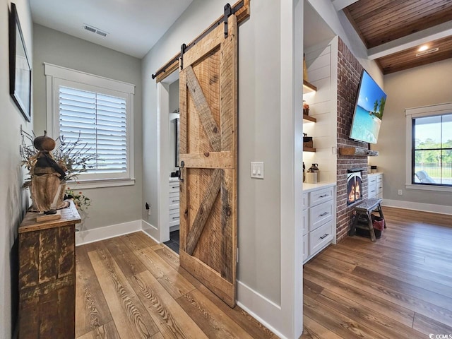 2300 Tansy Rd, Loris, SC 29569 - entrance foyer with a barn door, wood-type flooring, baseboards, and a brick fireplace