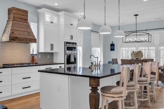 kitchen featuring custom exhaust hood, a chandelier, appliances with stainless steel finishes, dark countertops, and recessed lighting