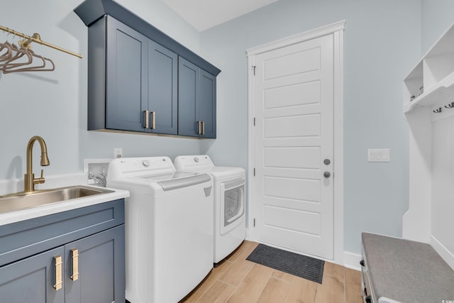 clothes washing area featuring cabinet space, separate washer and dryer, and light wood finished floors