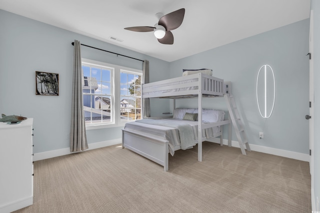 carpeted bedroom featuring baseboards and a ceiling fan