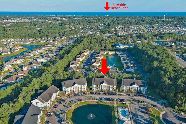 aerial view of property and surrounding area with a large body of water and nearby suburban area