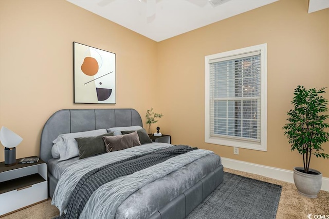 carpeted bedroom featuring baseboards and a ceiling fan