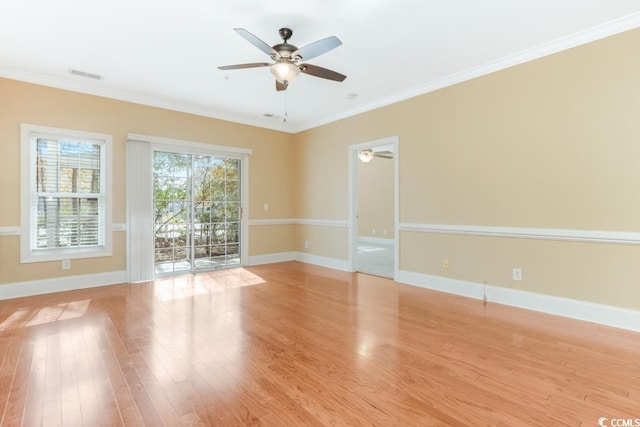 empty room featuring a ceiling fan, wood finished floors, baseboards, and ornamental molding