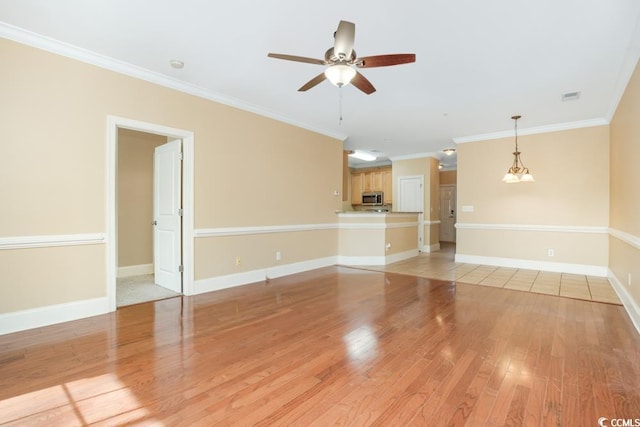 unfurnished living room featuring ceiling fan, light wood-type flooring, crown molding, and baseboards