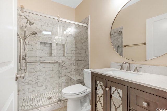 bathroom featuring toilet, a stall shower, and vanity