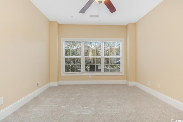 spare room with carpet, a ceiling fan, and baseboards