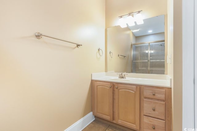 full bathroom with vanity, tile patterned flooring, a shower with shower door, and baseboards