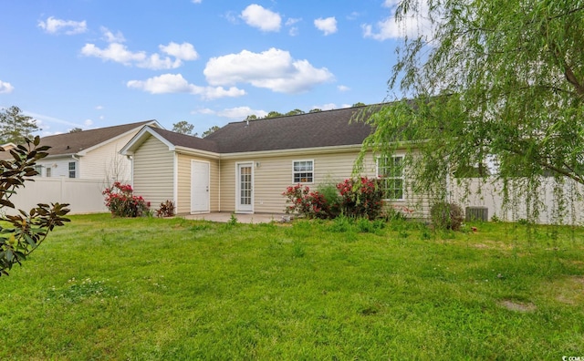 rear view of property with fence, a lawn, a patio area, and central AC