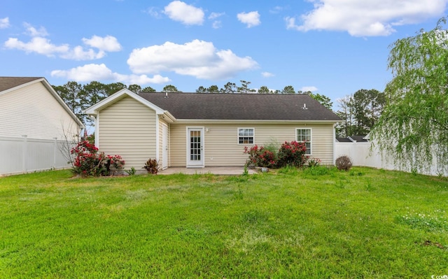 rear view of house with a lawn, a patio, and a fenced backyard