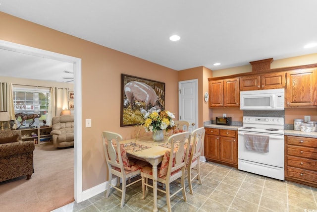 kitchen with recessed lighting, light countertops, brown cabinets, and white appliances