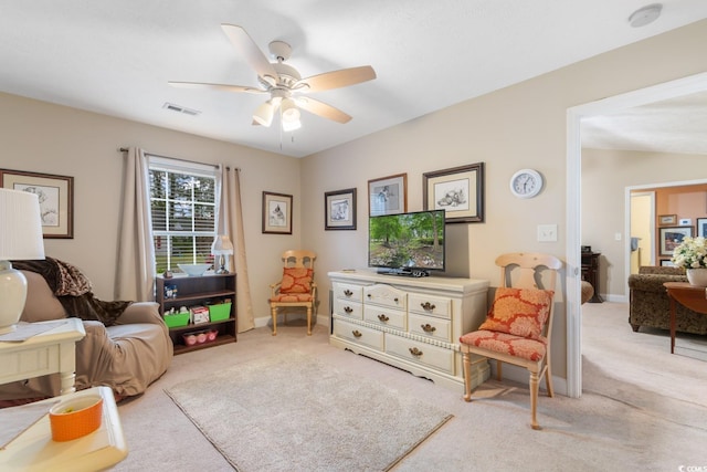 interior space featuring baseboards, ceiling fan, light colored carpet, and visible vents