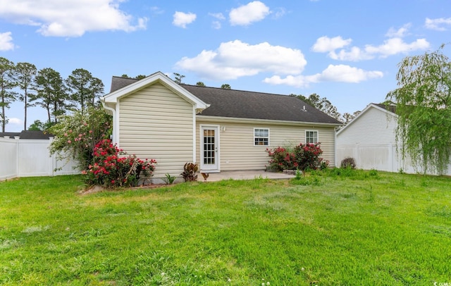 rear view of property featuring a patio, a fenced backyard, and a lawn