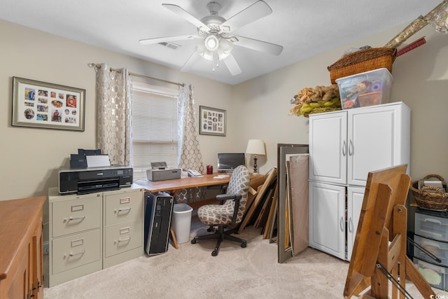 home office featuring light colored carpet, a ceiling fan, and visible vents