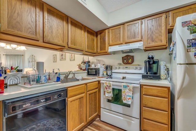 4601 Greenbriar Dr Unit 201, Little River, SC 29566 - kitchen featuring under cabinet range hood, light countertops, a sink, white appliances, and brown cabinetry