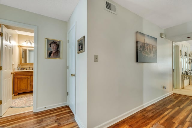 4601 Greenbriar Dr Unit 201, Little River, SC 29566 - corridor with baseboards, wood finished floors, visible vents, and a sink