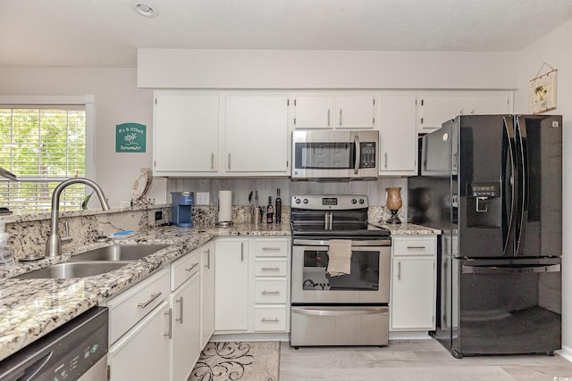 619 Waterway Village Blvd Unit 7C, Myrtle Beach, SC 29579 - kitchen featuring light stone counters, a sink, light wood-style floors, stainless steel appliances, and white cabinetry