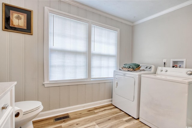 1028 1st Ave S, North Myrtle Beach, SC 29582 - laundry room with washing machine and dryer, light wood-type flooring, visible vents, crown molding, and laundry area