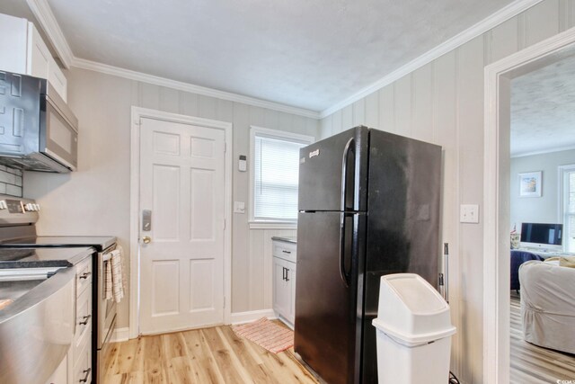 1028 1st Ave S, North Myrtle Beach, SC 29582 - kitchen featuring white cabinets, crown molding, stainless steel appliances, and light wood-type flooring