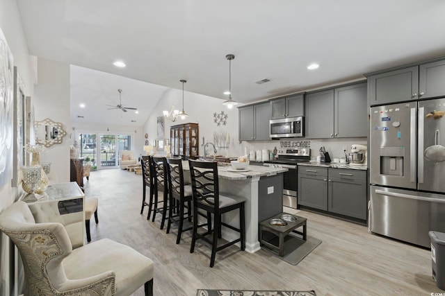 136 Queens Cove Pl Unit B, Myrtle Beach, SC 29579 - kitchen featuring appliances with stainless steel finishes, gray cabinetry, a chandelier, light wood-style flooring, and light stone counters