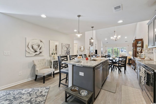 136 Queens Cove Pl Unit B, Myrtle Beach, SC 29579 - kitchen with a sink, appliances with stainless steel finishes, a chandelier, a breakfast bar area, and light wood finished floors