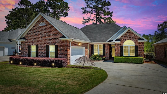 view of front facade featuring driveway, brick siding, a garage, a shingled roof, and a front lawn
