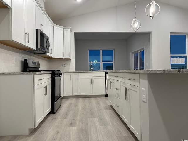 190 Glengrove Ln, Murrells Inlet, SC 29576 - kitchen with gas stove, vaulted ceiling, stainless steel microwave, light wood finished floors, and decorative backsplash