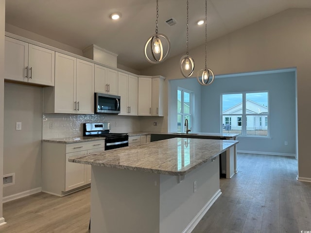 190 Glengrove Ln, Murrells Inlet, SC 29576 - kitchen with stainless steel appliances, a peninsula, lofted ceiling, tasteful backsplash, and white cabinets
