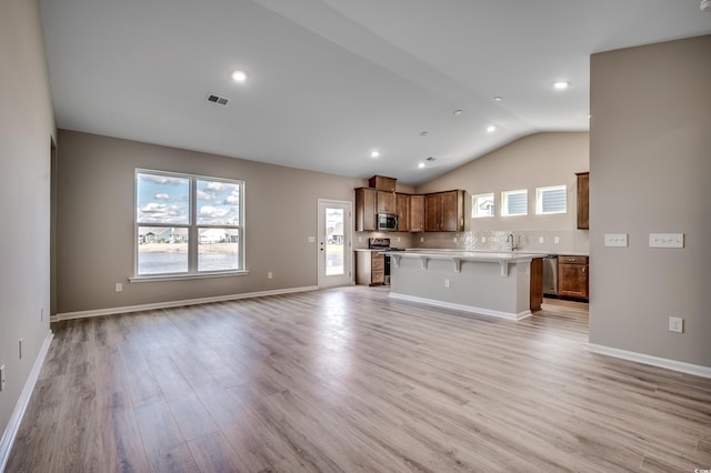 186 Glengrove Ln, Murrells Inlet, SC 29576 - unfurnished living room featuring light wood-style floors, visible vents, vaulted ceiling, and a healthy amount of sunlight