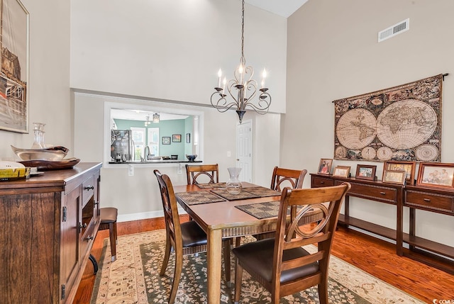 4755 Lightkeepers Way Unit 15-E, Little River, SC 29566 - dining area with a towering ceiling, visible vents, wood finished floors, baseboards, and a notable chandelier