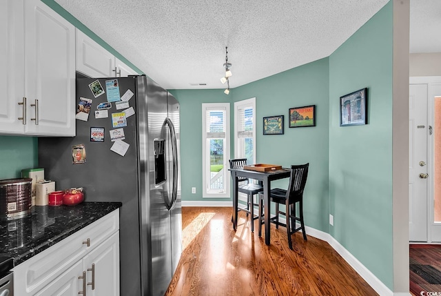 4755 Lightkeepers Way Unit 15-E, Little River, SC 29566 - kitchen with baseboards, dark wood-style floors, stainless steel fridge, a textured ceiling, and white cabinetry