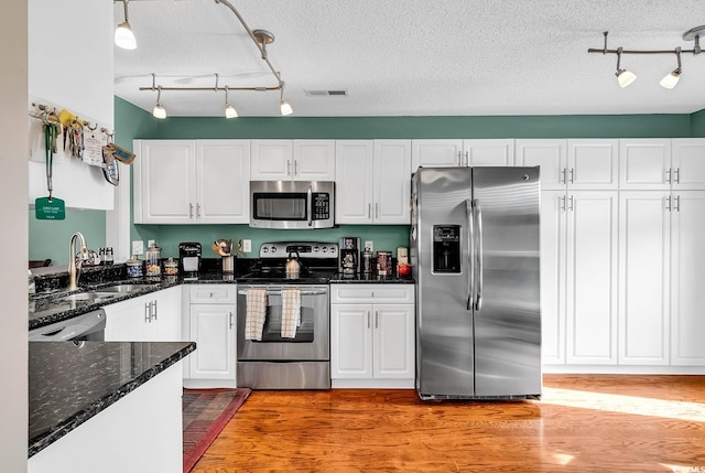 4755 Lightkeepers Way Unit 15-E, Little River, SC 29566 - kitchen with appliances with stainless steel finishes, a sink, rail lighting, white cabinetry, and visible vents