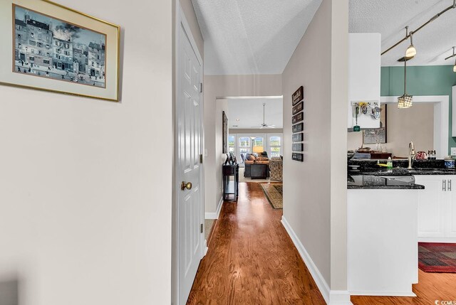 4755 Lightkeepers Way Unit 15-E, Little River, SC 29566 - corridor with baseboards, a sink, a textured ceiling, and wood finished floors