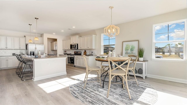 728 Choctaw Dr, Conway, SC 29526 - kitchen with stainless steel appliances, tasteful backsplash, light wood-style flooring, a chandelier, and an island with sink