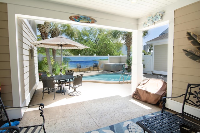 view of patio with outdoor dining area, a fenced backyard, a hot tub, and a fenced in pool