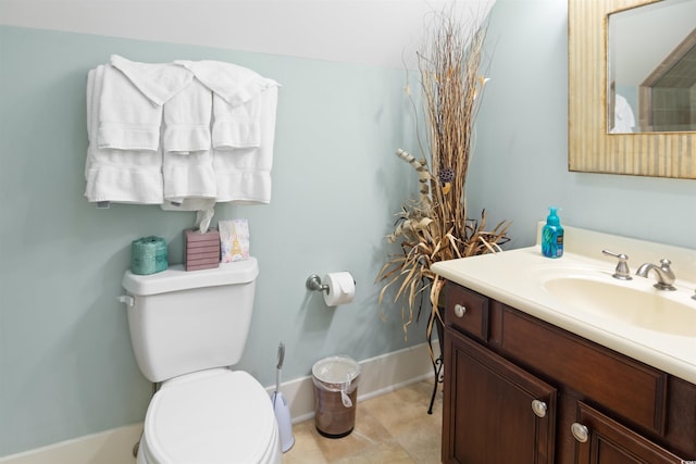 bathroom with vanity, baseboards, tile patterned flooring, and toilet