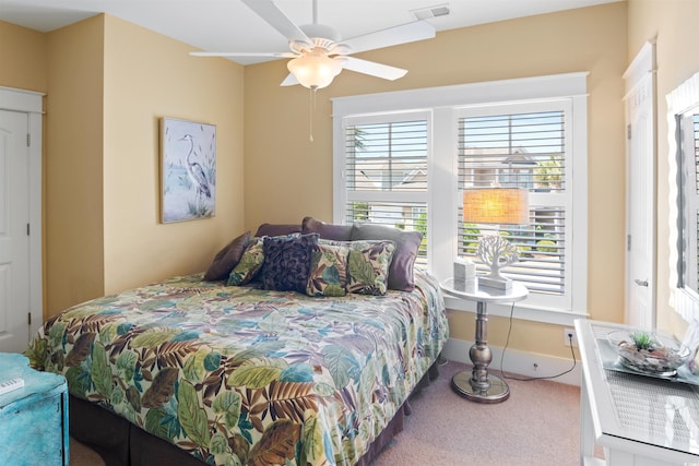 carpeted bedroom with visible vents, ceiling fan, and multiple windows