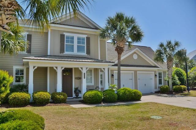 traditional-style home with covered porch, board and batten siding, a front yard, concrete driveway, and an attached garage