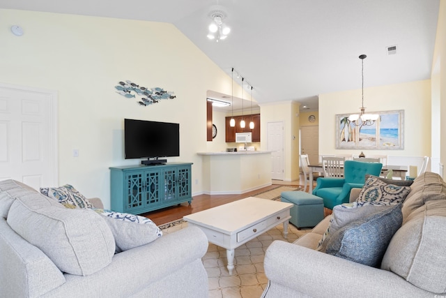 living area featuring vaulted ceiling and a chandelier