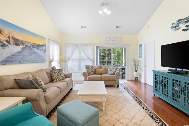 living area featuring wood finished floors, high vaulted ceiling, and baseboards