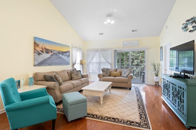 living room with high vaulted ceiling, wood finished floors, and baseboards