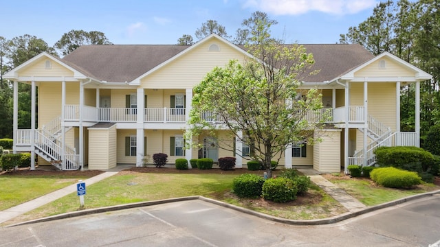 view of front of house featuring stairs, a porch, and a front yard