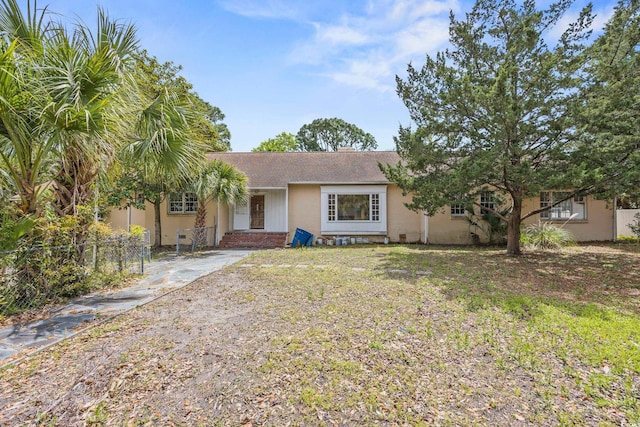 ranch-style home with fence and a shingled roof