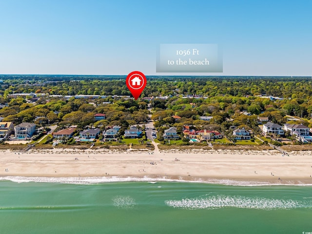 drone / aerial view with a beach view, a residential view, and a water view
