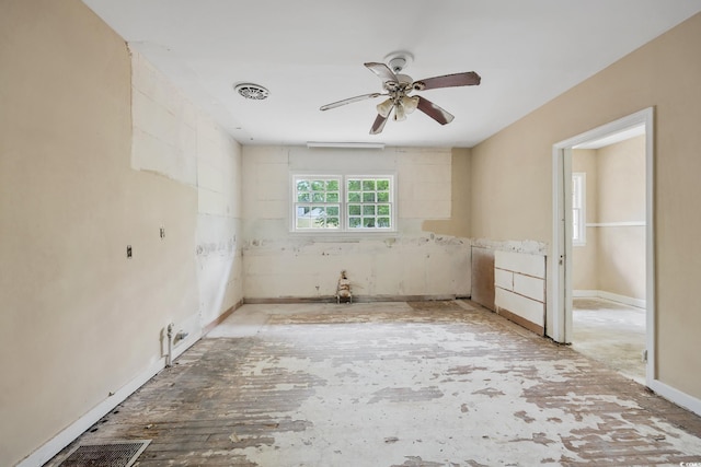 empty room featuring ceiling fan, baseboards, and visible vents