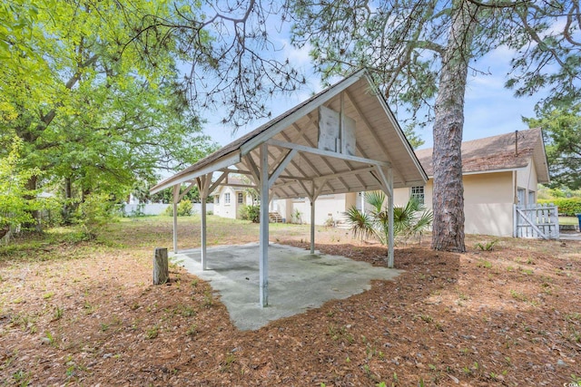 view of yard featuring a detached carport, a patio, and fence
