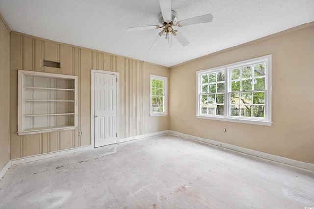 unfurnished room featuring a textured ceiling, a ceiling fan, and baseboards