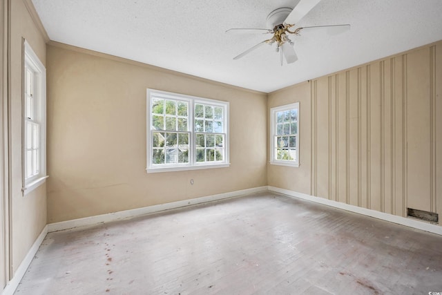 spare room with wood finished floors, a ceiling fan, baseboards, and ornamental molding