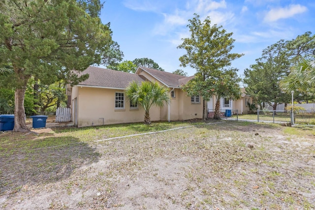 single story home with stucco siding, a gate, and fence