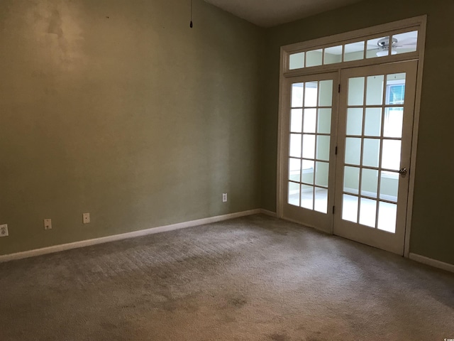 carpeted empty room featuring baseboards