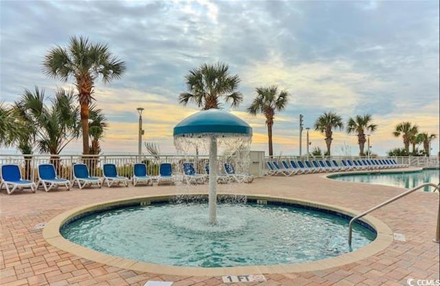 2701 S Ocean Blvd Unit 1507, North Myrtle Beach, SC 29582 - pool at dusk featuring a patio area, a community pool, and fence